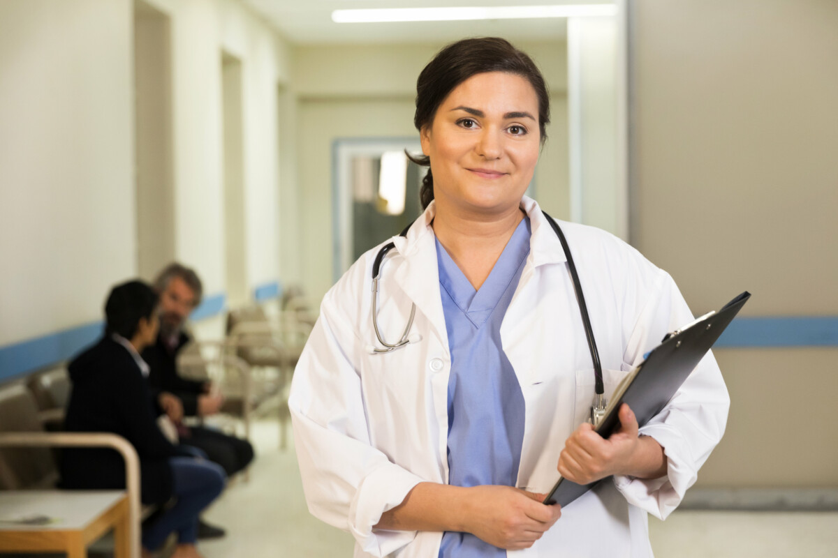 a-doctor-smiles-while-holding-her-clipboard a-doctor-smiles-while-holding-her-clipboard